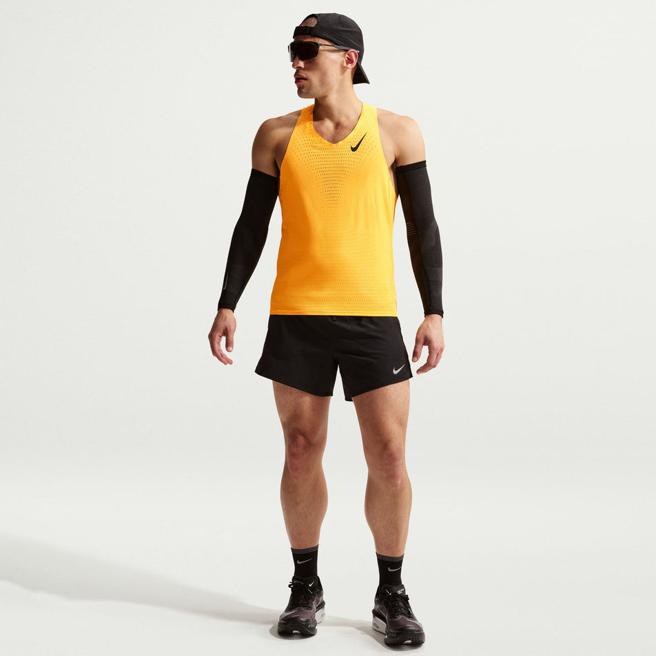 Front view of a model wearing the Nike Men's AeroSwift Dri-FIT ADV Running Singlet in the Laser Orange/Black colourway.
