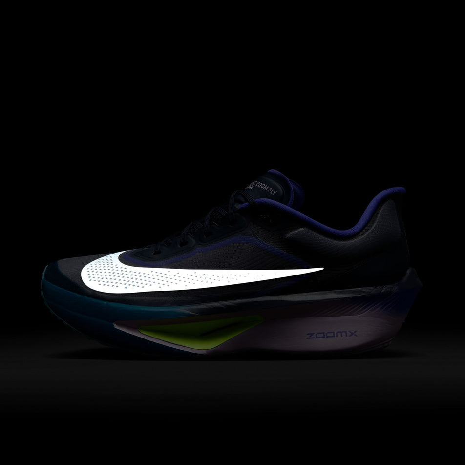 The reflective Swoosh on the lateral side of the left shoe from a pair of Nike Men's Zoom Fly 6 Road Running Shoes in the Obsidian/White-Persian Violet-Volt colourway. (8753452351650)