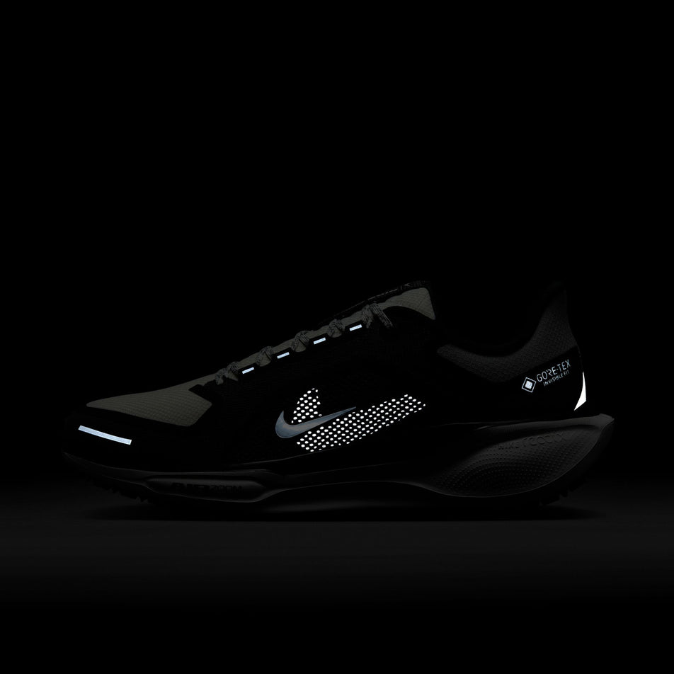 The reflective details on the lateral side of the left shoe from a pair of Nike Men's Pegasus 41 GORE-TEX Road Running Shoes in the Black/Summit White-Anthracite-Iron Grey colourway. (8754793185442)
