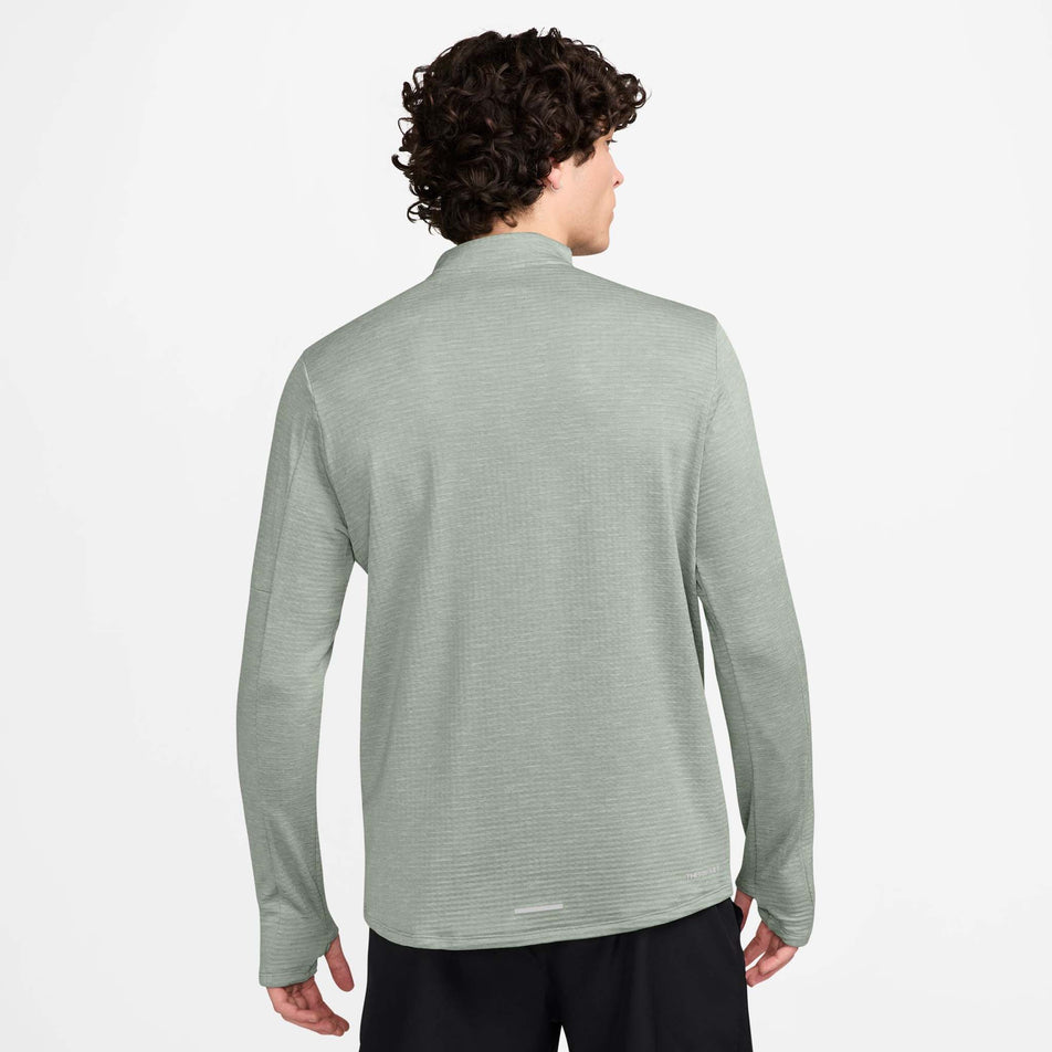 The back view of a model wearing a Nike Men's Therma-FIT Water-Repellent Element 1/2-Zip Running Top in the Jade Horizon/Reflective Silv colourway. Model is also wearing Nike shorts. (8497732518050)
