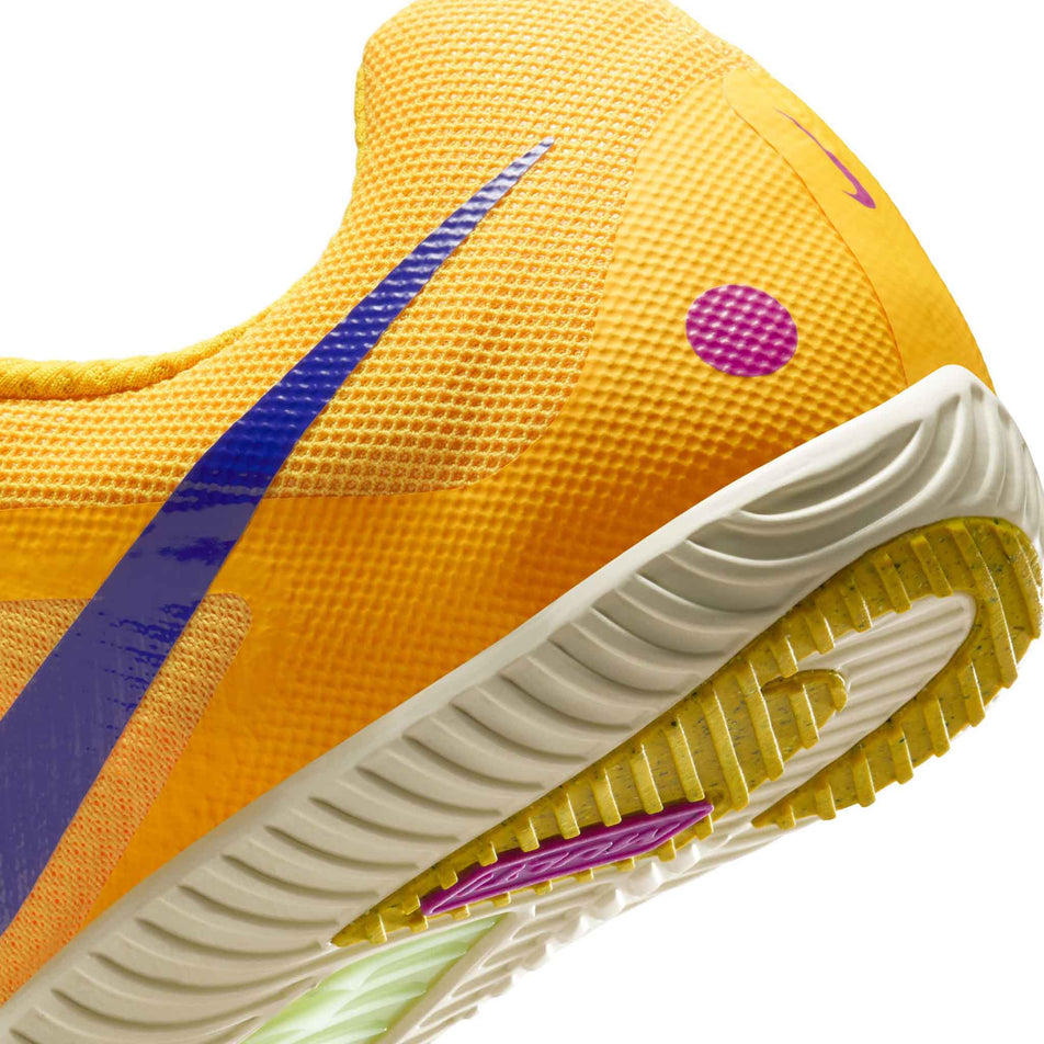 Close-up view of the rearfoot section of the left shoe from a pair of Nike Unisex Zoom Rival Track & Field Multi-Event Spikes in the Citron Pulse/Indigo Burst-Volt Glow colourway.