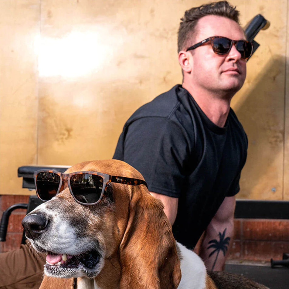 A model and a dog each wearing a pair of goodr Bosleys Basset Hound Dreams - OG - Running Sunglasses