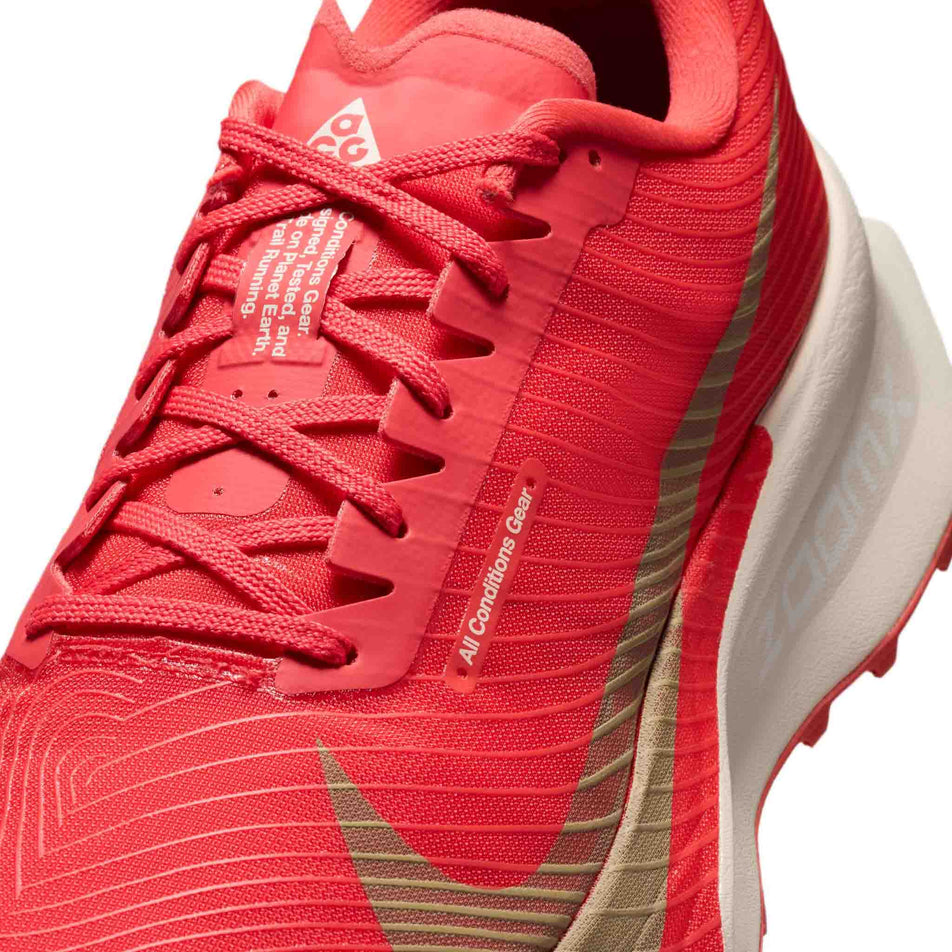 Close-up view of the upper of the left shoe from a pair of Nike Unisex ACG Ultrafly Trail Racing Shoes in the Light Crimson/Pure Platinum-Summit White colourway.