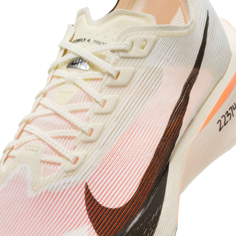 Angled view of the left shoe from a pair of Nike Women's Vaporfly 4 Proto Road Racing Shoes in the Sail/Black-Total Orange-White colourway. (8635888500898)