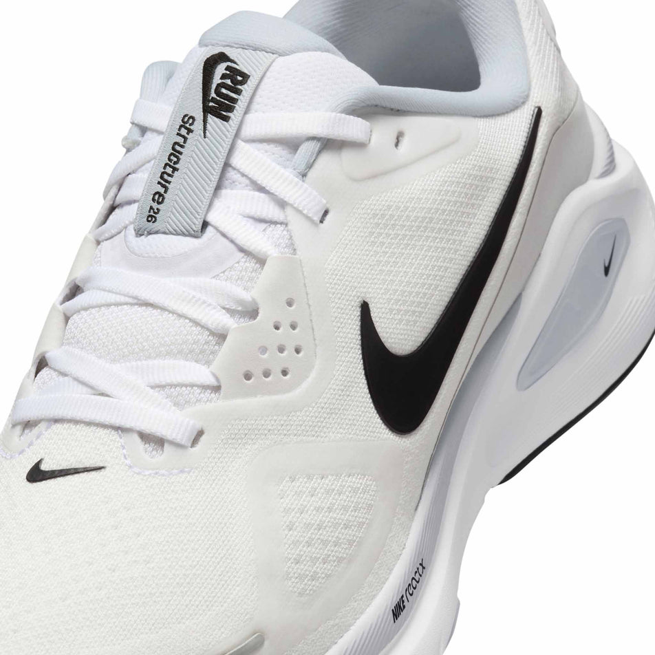 Close-up view of the upper of the left shoe from a pair of Nike Women's Structure 26 Road Running Shoes in the White/Black-Pure Platinum colourway.