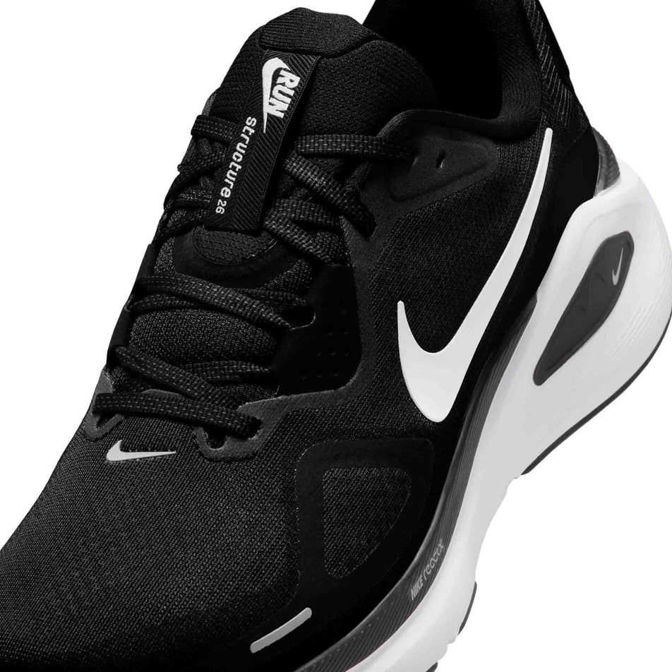Close up of the upper of the left shoe from a pair of Nike Men's Structure 26 Road Running Shoes in the Black/White-Cool Grey-Metallic Silver colourway. (8684582666402)