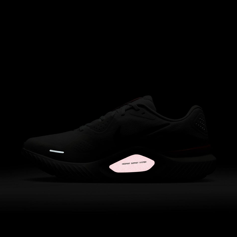 The reflective detail on the medial side of the right shoe from a pair of Nike Men's Structure 26 Road Running Shoes in the White/Black-Bright Crimson-Photon Dust colourway. (8684589973666)