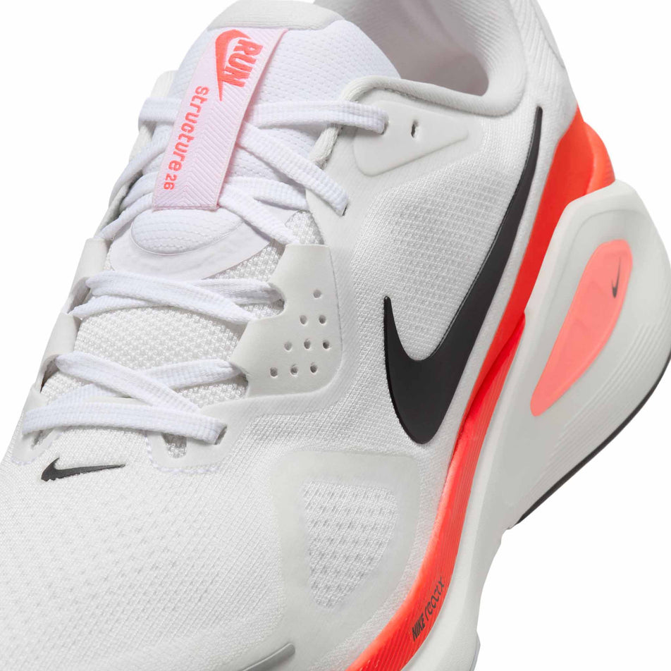 Close up of the upper of the left shoe from a pair of Nike Men's Structure 26 Road Running Shoes in the White/Black-Bright Crimson-Photon Dust colourway. (8684589973666)