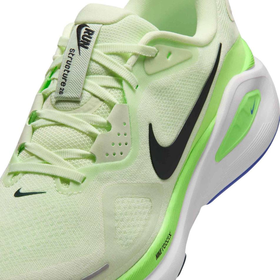 Close-up view of the upper of the left shoe from a pair of Nike Men's Structure 26 Road Running Shoes in the Volt Tint/Black Spruce-Lime Blast colourway.
