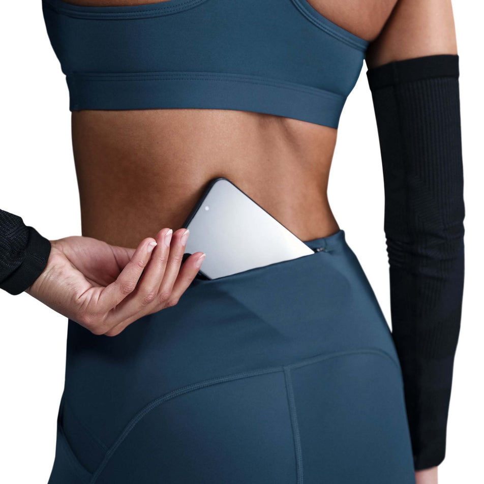 Close up view of the zippered back pocket on the Nike Women's Swift Dri-FIT High Rise 7/8 Running Tights in the Armory Navy/Reflective Silver colourway. (8560458563746)