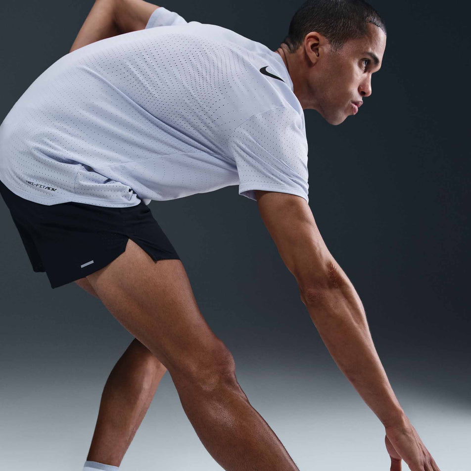 Angled view of a model wearing the Nike Men's AeroSwift Dri-FIT ADV Short-Sleeve Running Top in the Ghost/Black colourway. (8710830620834)