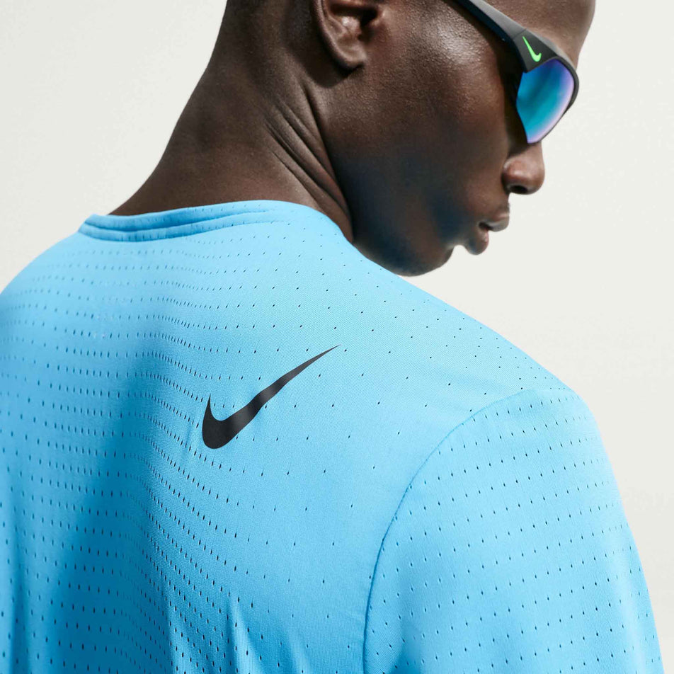 Back view of a model wearing the Nike Men's AeroSwift Dri-FIT ADV Short-Sleeve Running Top in the Light Current Blue/Black colourway.