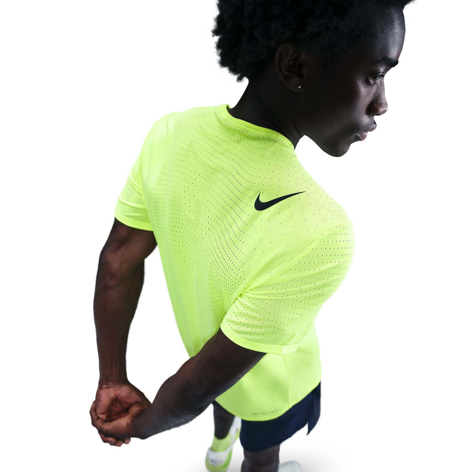 Angled view of a model wearing the Nike Men's AeroSwift Dri-FIT ADV Short-Sleeve Running Top in the Volt/Black colourway. (8778190749858)