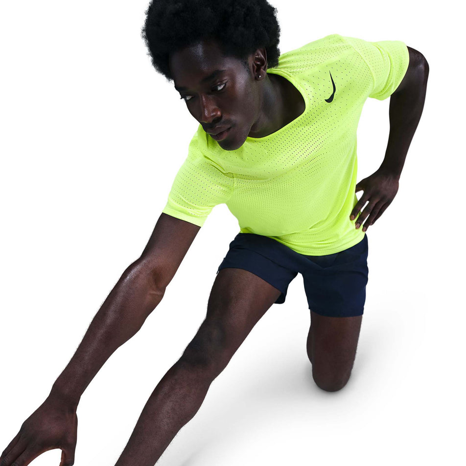 Angled view of a model wearing the Nike Men's AeroSwift Dri-FIT ADV Short-Sleeve Running Top in the Volt/Black colourway. (8778190749858)
