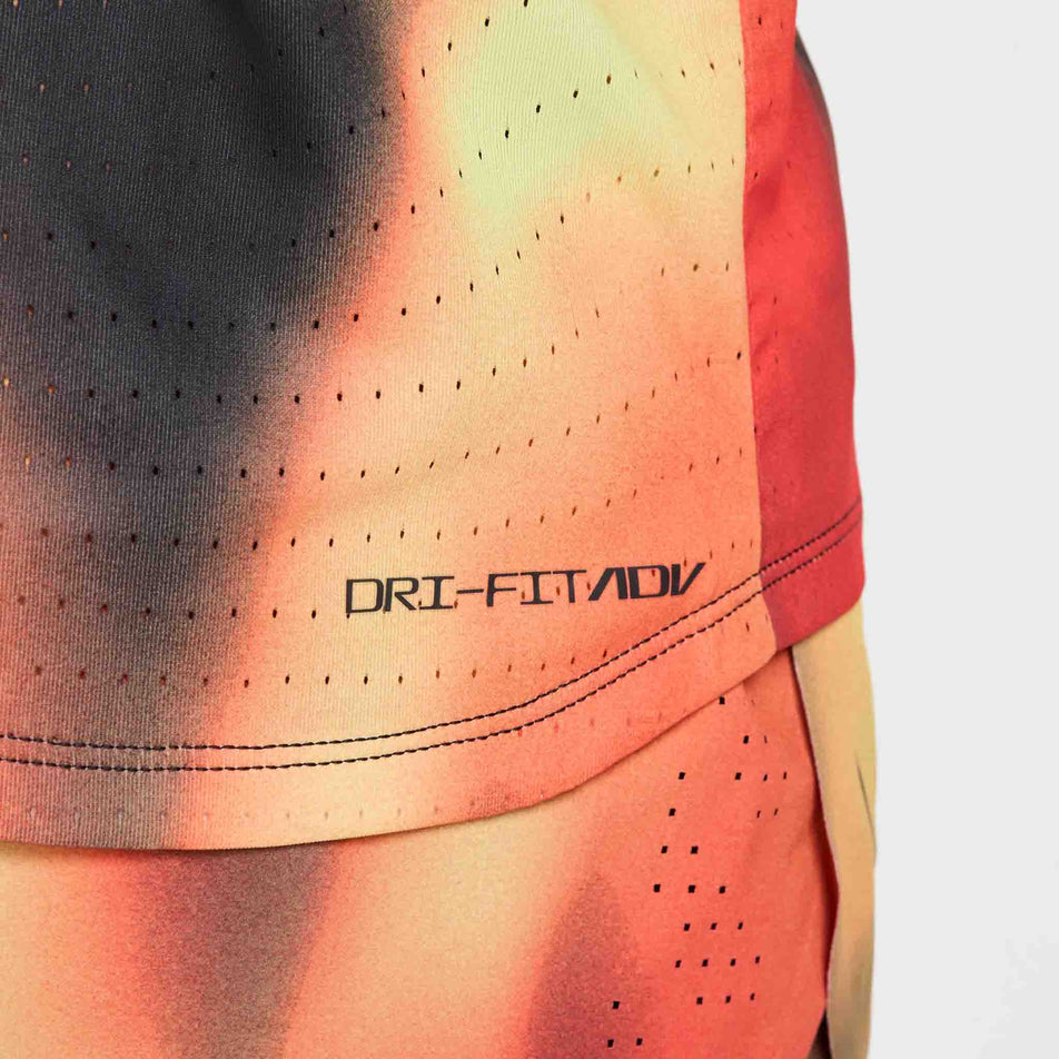 The Dri-FIT ADV logo on the Nike Men's Dri-FIT AeroSwift Elite Entry Singlet in the Light Lemon Twist/Light Crimson/Black/Black colourway. (8574167613602)