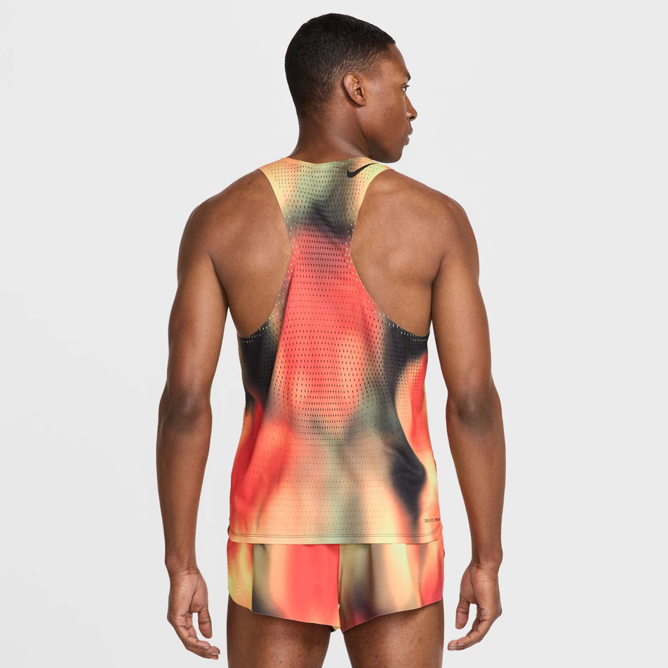 Back view of a model wearing the Nike Men's Dri-FIT AeroSwift Elite Entry Singlet in the Light Lemon Twist/Light Crimson/Black/Black colourway. (8574167613602)
