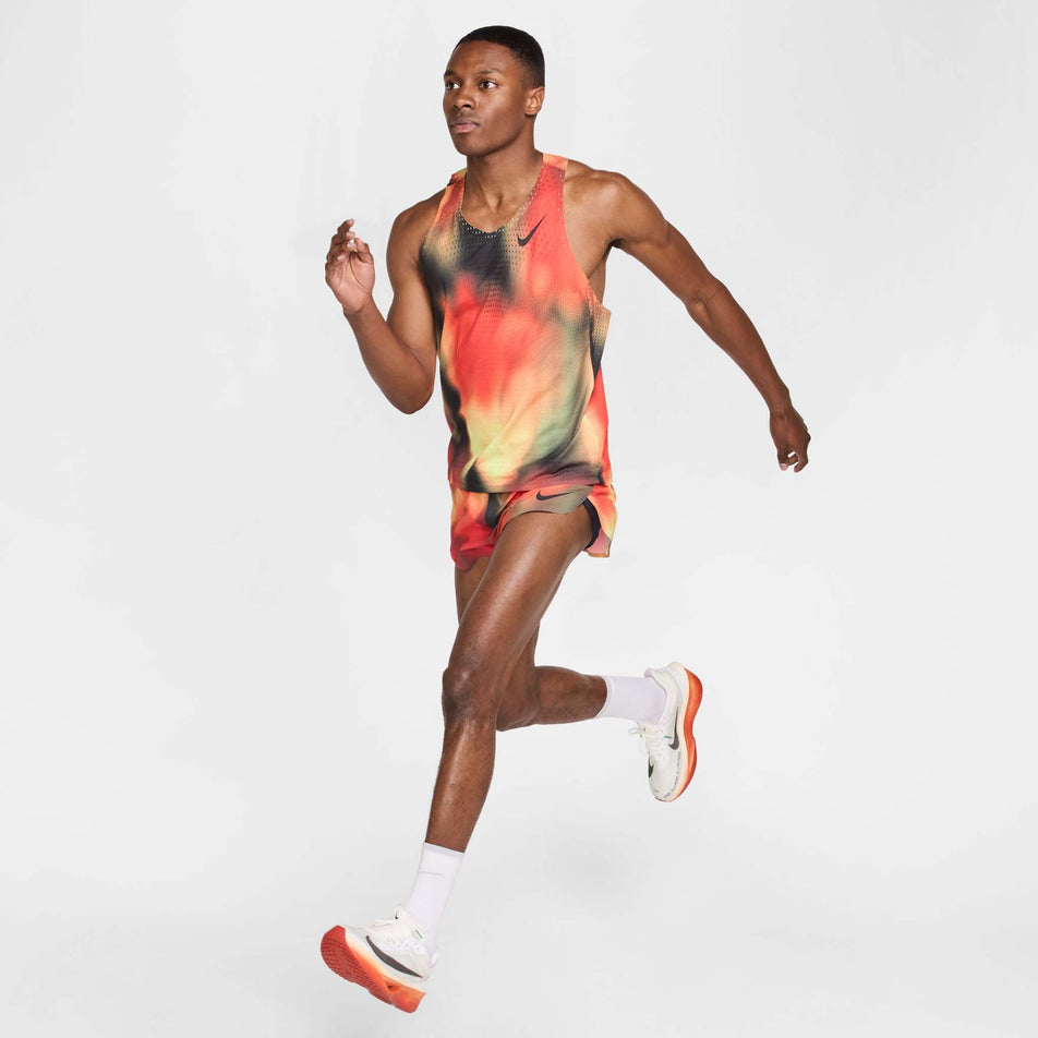 Front view of a model wearing the Nike Men's Dri-FIT AeroSwift Elite Entry Singlet in the Light Lemon Twist/Light Crimson/Black/Black colourway. (8574167613602)