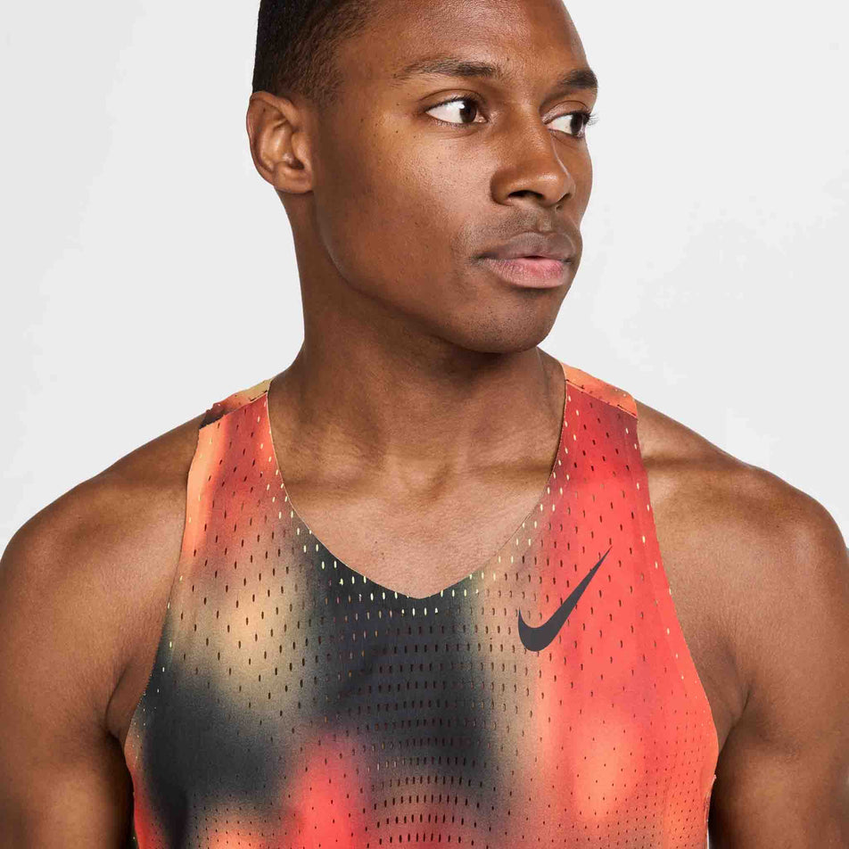 Front view of a model wearing the Nike Men's Dri-FIT AeroSwift Elite Entry Singlet in the Light Lemon Twist/Light Crimson/Black/Black colourway. (8574167613602)