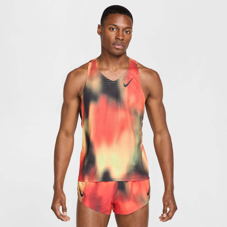 Front view of a model wearing the Nike Men's Dri-FIT AeroSwift Elite Entry Singlet in the Light Lemon Twist/Light Crimson/Black/Black colourway. (8574167613602)