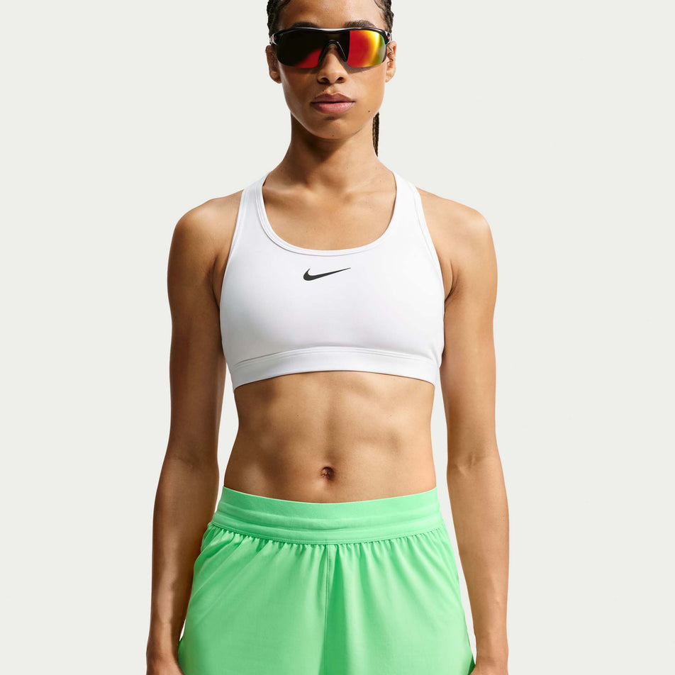 Front view of a model wearing the Nike Women's Swift Dri-FIT Mid-Rise 2-in-1 Running Shorts in the Illusion Green colourway.