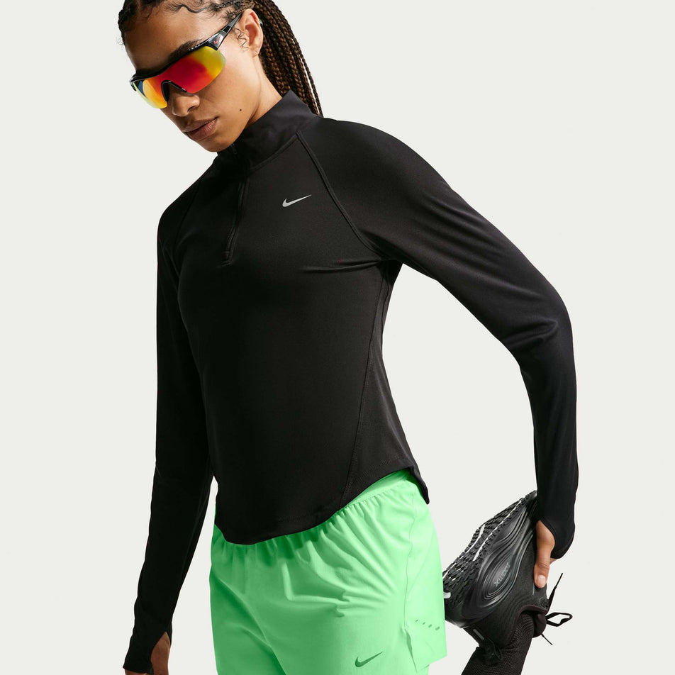 Angled view of a model wearing the Nike Women's Swift Dri-FIT Mid-Rise 2-in-1 Running Shorts in the Illusion Green colourway.