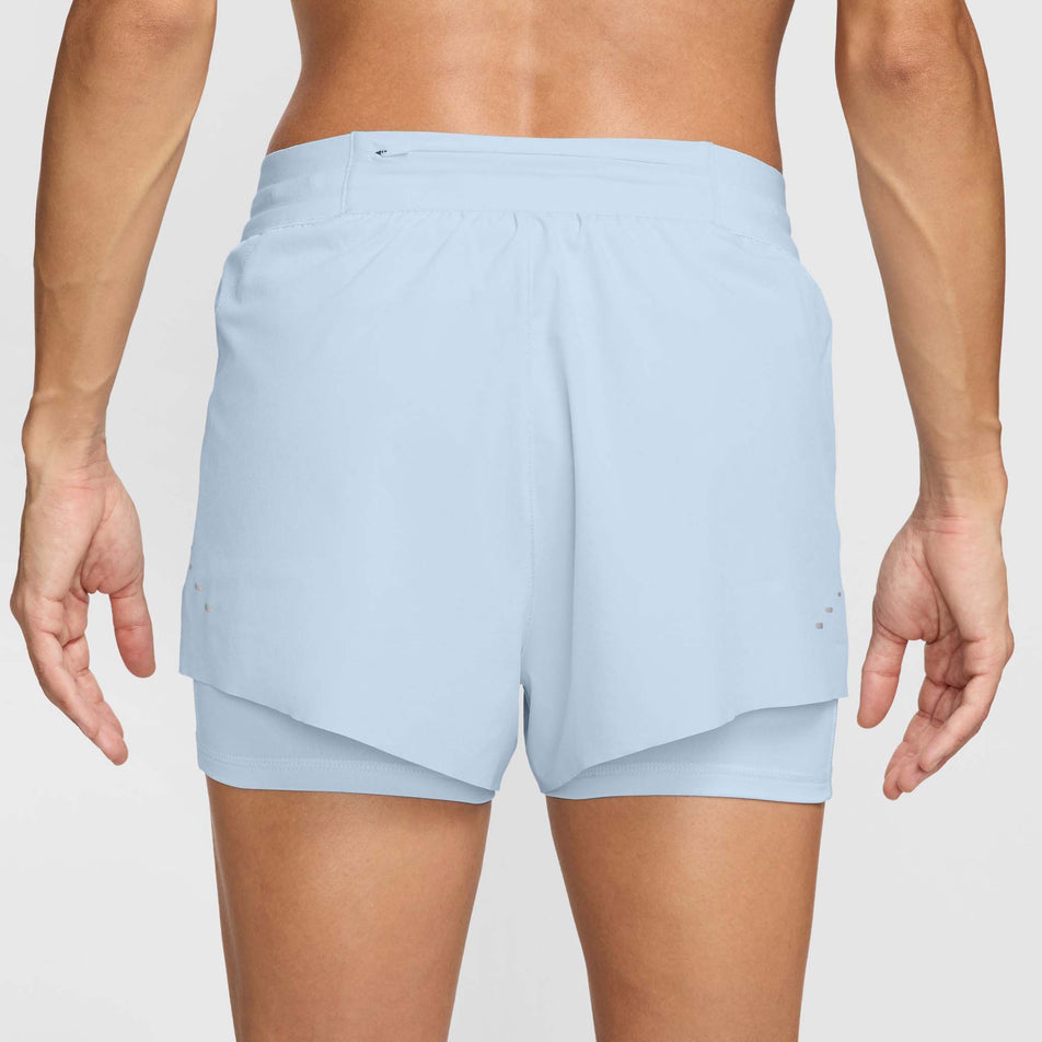 Back view of a model wearing a pair of Nike Women's Swift Dri-FIT Mid Rise 2-in-1 Running Shorts in the Blue Tint/Reflective Silv colourway (8620122800290)