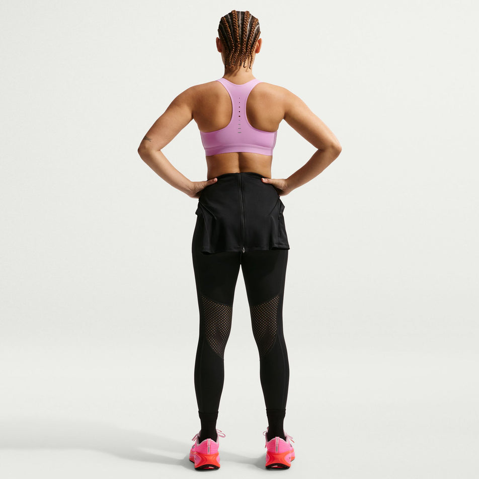 Back view of a model wearing the Nike Women's Swift High-Support Lightly Lined Sports Bra in the Light Magenta/Reflective Silver colourway.