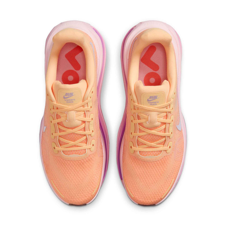 The uppers of a pair of Nike Women's Vomero Premium Road Running Shoes in the Tangerine Tint/Tattoo-Bright Crimson colourway.
