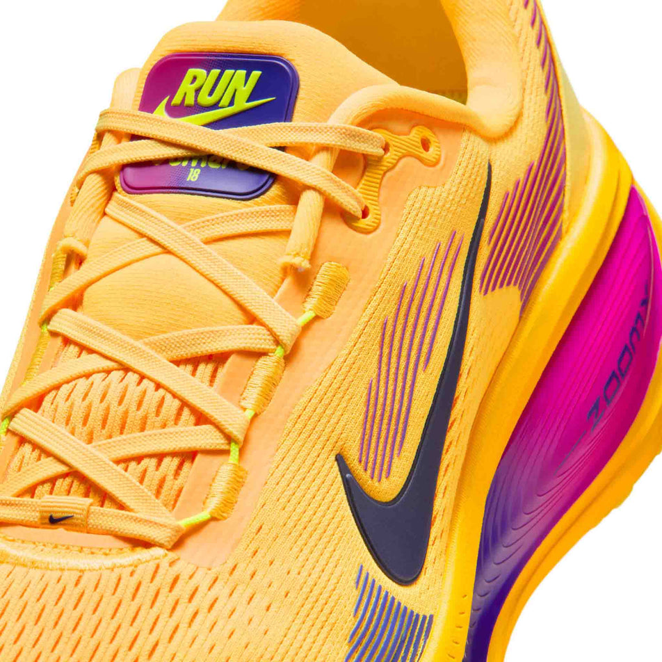 Close-up view of the upper of the left shoe from a pair of Nike Men's Vomero 18 Road Running Shoes in the Citron Pulse/Blue Void-laser Orange colourway.