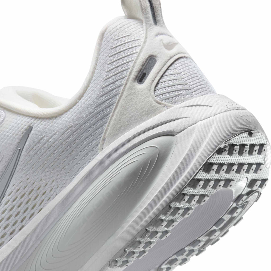 Close up of the midsole of the left shoe from a pair of Nike Women's Vomero 18 Road Running Shoes in the White/Metallic Silver-Photon Dust colourway. (8686789361826)