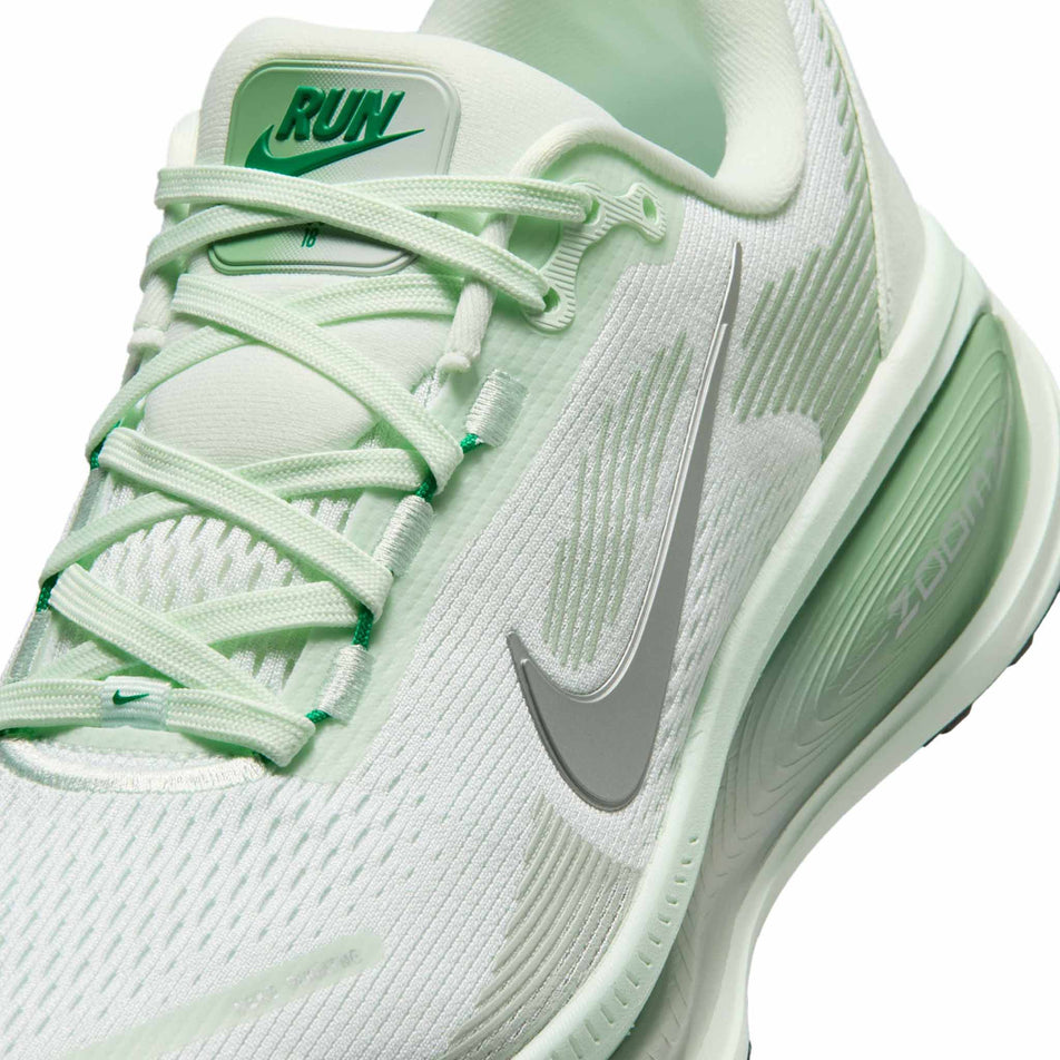 Close-up view of the upper of the left shoe from a pair of Nike Women's Vomero 18 Road Running Shoes in the Barely Green/Metallic Silver-Steam colourway.