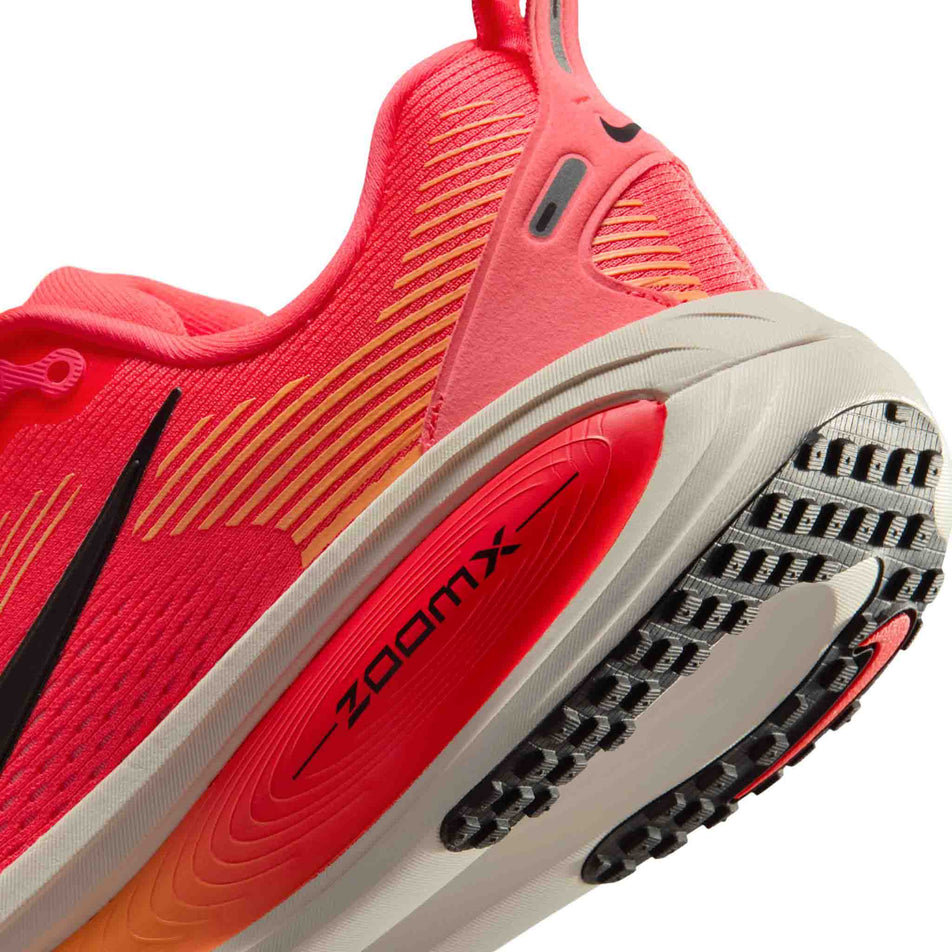 Close-up view of the rearfoot section of the left shoe from a pair of Nike Women's Vomero 18 Road Running Shoes in the Hot Lava/Black-Chalk-Orange Pulse colourway.