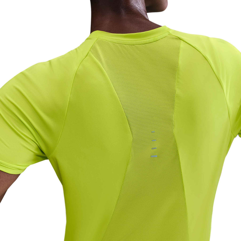 Back view of a model wearing the Nike Women's Swift Dri-FIT Short-Sleeve Running Top in the Cyber/Reflective Silver colourway. (8756557775010)