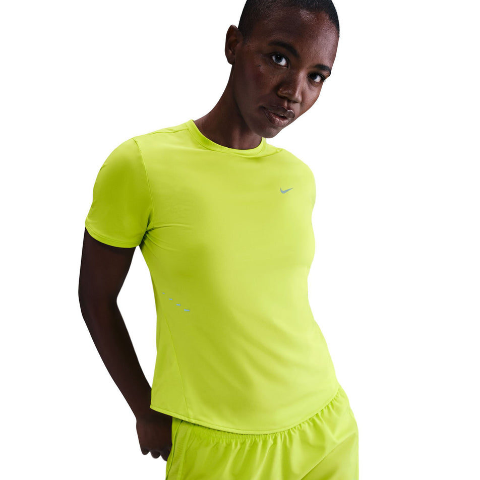Front view of a model wearing the Nike Women's Swift Dri-FIT Short-Sleeve Running Top in the Cyber/Reflective Silver colourway. (8756557775010)