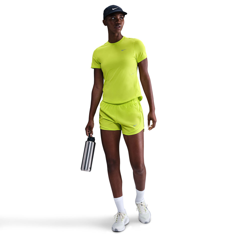 Front view of a model wearing the Nike Women's Swift Dri-FIT Short-Sleeve Running Top in the Cyber/Reflective Silver colourway. (8756557775010)