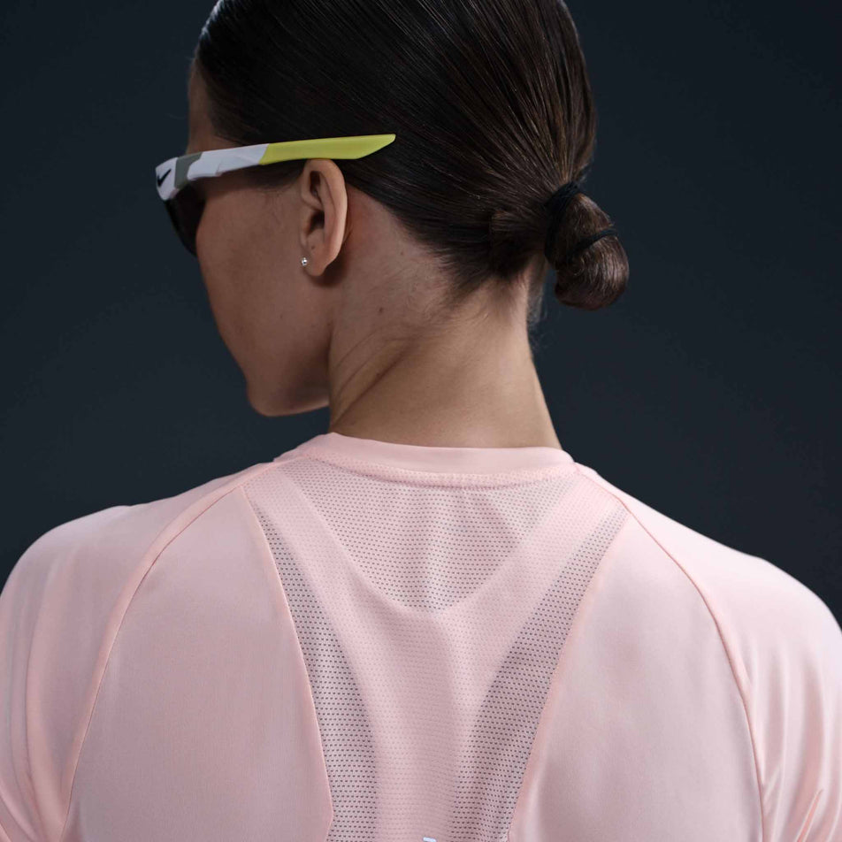Back view of a model wearing the Nike Women's Swift Dri-FIT Short-Sleeve Running Top in the Atmosphere/Reflective Silver colourway. (8620130762914)
