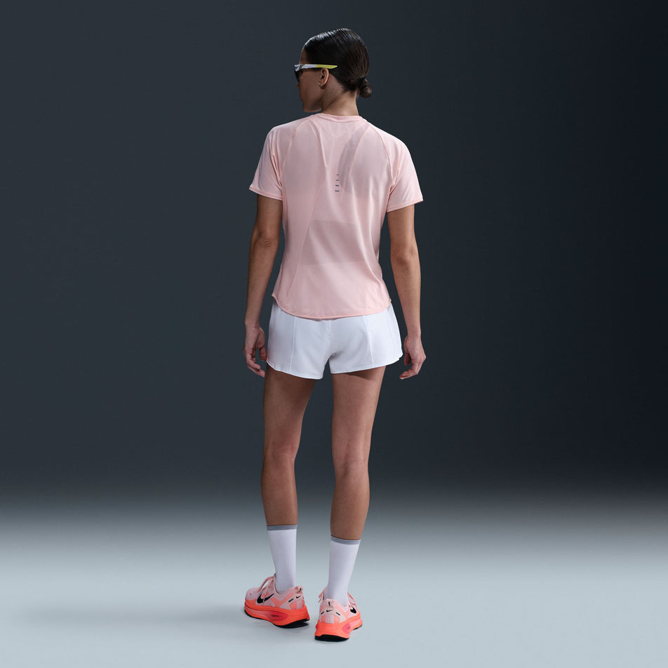 Back view of a model wearing the Nike Women's Swift Dri-FIT Short-Sleeve Running Top in the Atmosphere/Reflective Silver colourway. (8620130762914)