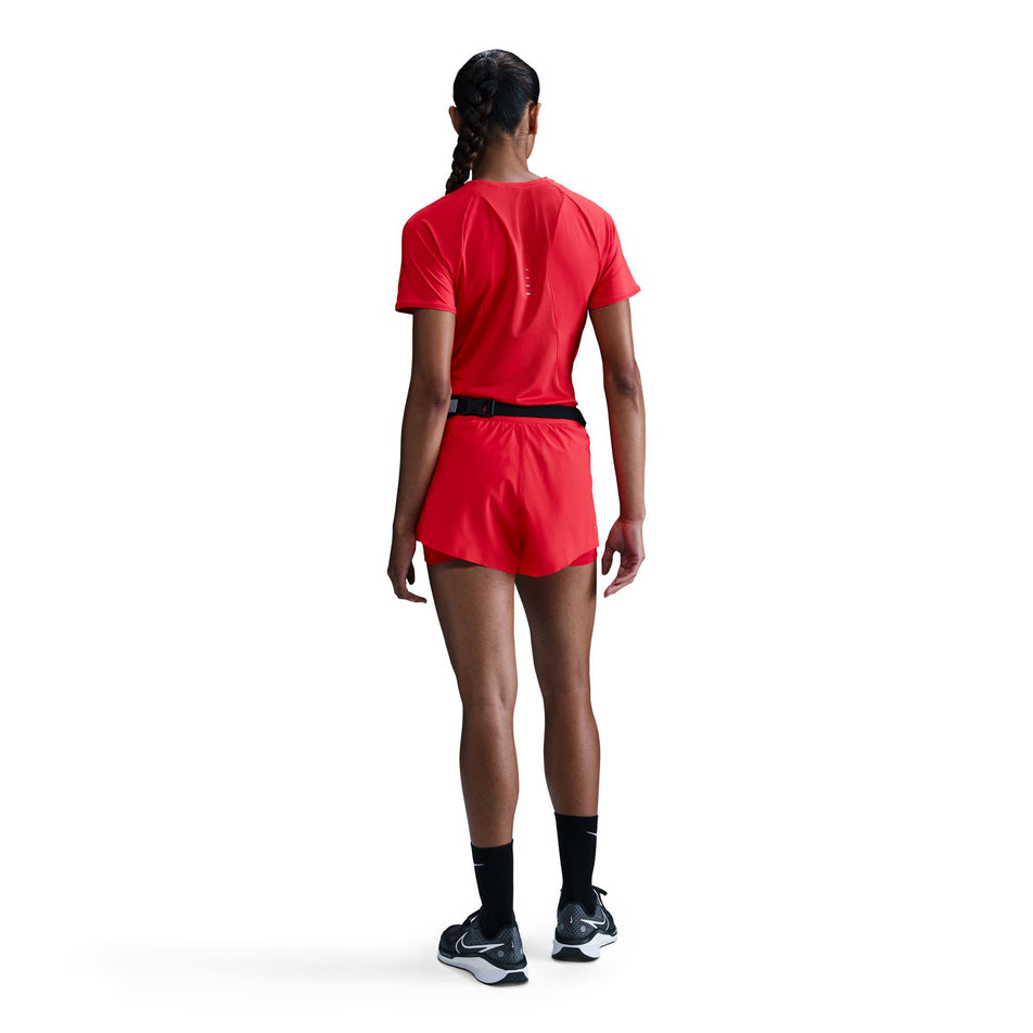 Back view of a model wearing a Nike Women's Swift Dri-FIT Short-Sleeve Running Top in the Light Crimson/Reflective Silver. (8560485662882)