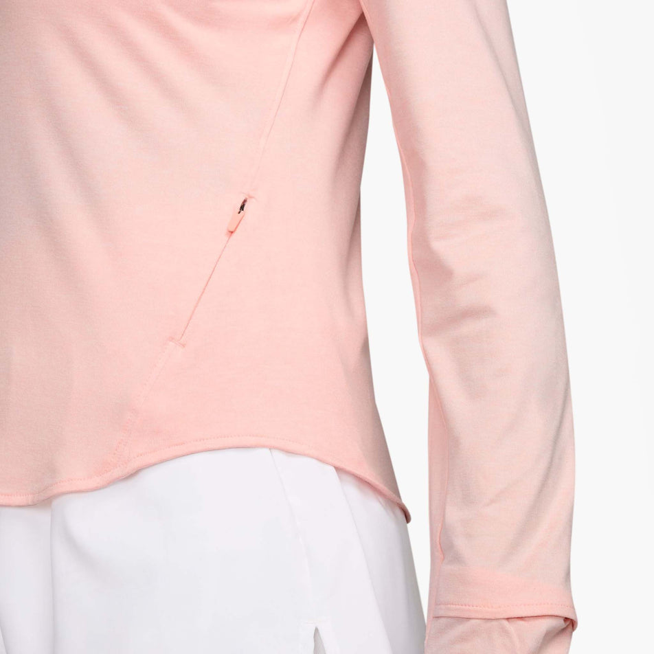 Close up of the zip on the left-hand side of the Nike Women's Swift Dri-FIT UV 1/4-Zip Long Sleeve Running Top in the Atmosphere/Heather/Reflective Silver colourway. (8621654081698)