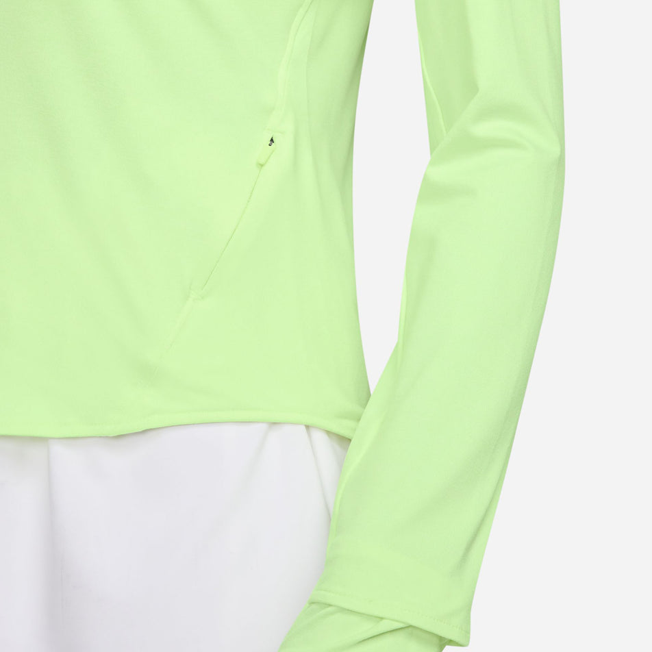 Close up of the zip on the left-hand side of the Nike Women's Swift Dri-FIT UV 1/4-Zip Long Sleeve Running Top in the Barely Volt/Heather/Reflective Silver colourway. (8621858193570)