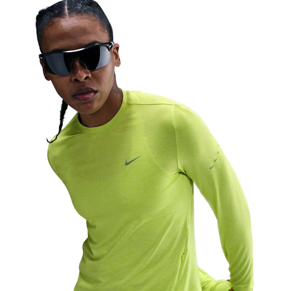 Front view of a model wearing the Nike Women's Swift Dri-FIT UV Long-Sleeve Crew-Neck Running Top in the Cyber/Heather/Reflective Silver colourway. (8756573110434)