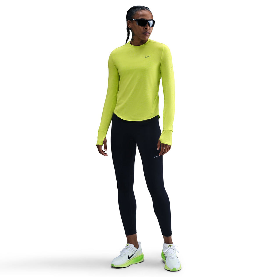 Front view of a model wearing the Nike Women's Swift Dri-FIT UV Long-Sleeve Crew-Neck Running Top in the Cyber/Heather/Reflective Silver colourway. (8756573110434)