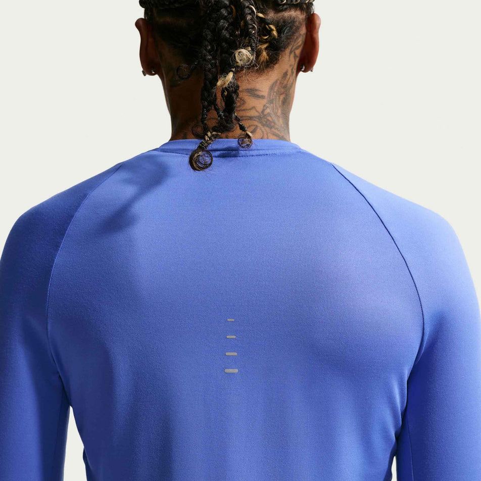 Back view of a model wearing the Nike Women's Swift Dri-FIT UV Long-Sleeve Crew-Neck Running Top in the Sapphire/Reflective Silver colourway.