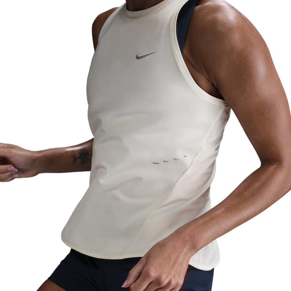 Front view of a model wearing the Nike Women's Swift Dri-FIT Running Tank Top in the Sail/Reflective Silver colourway. (8692446134434)