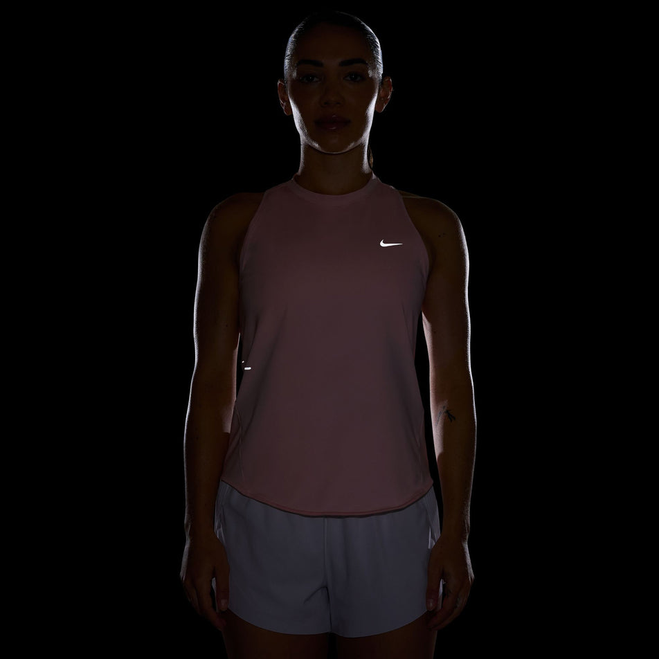 The reflective Swoosh on the front of the Nike Women's Swift Dri-FIT Running Tank Top in the Atmosphere/Reflective Silver colourway. (8620139970722)