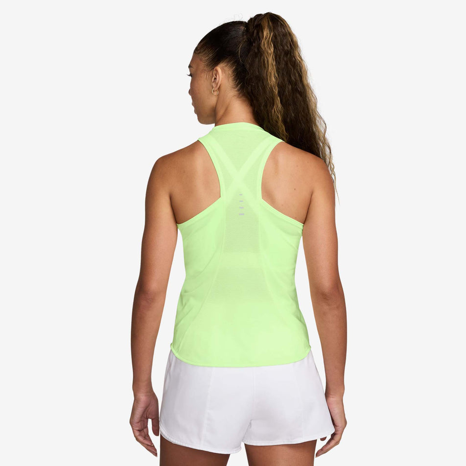 Back view of a model wearing the Nike Women's Swift Dri-FIT Running Tank Top in the Barely Volt/Reflective Silver colourway. (8620142952610)
