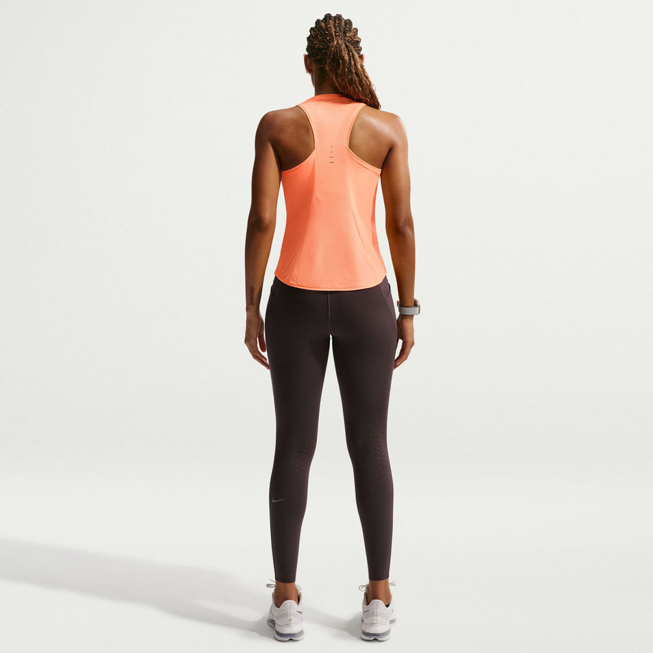 Back view of a model wearing the Nike Women's Swift Dri-FIT Running Tank Top in the Orange Pulse/Reflective Silver colourway.