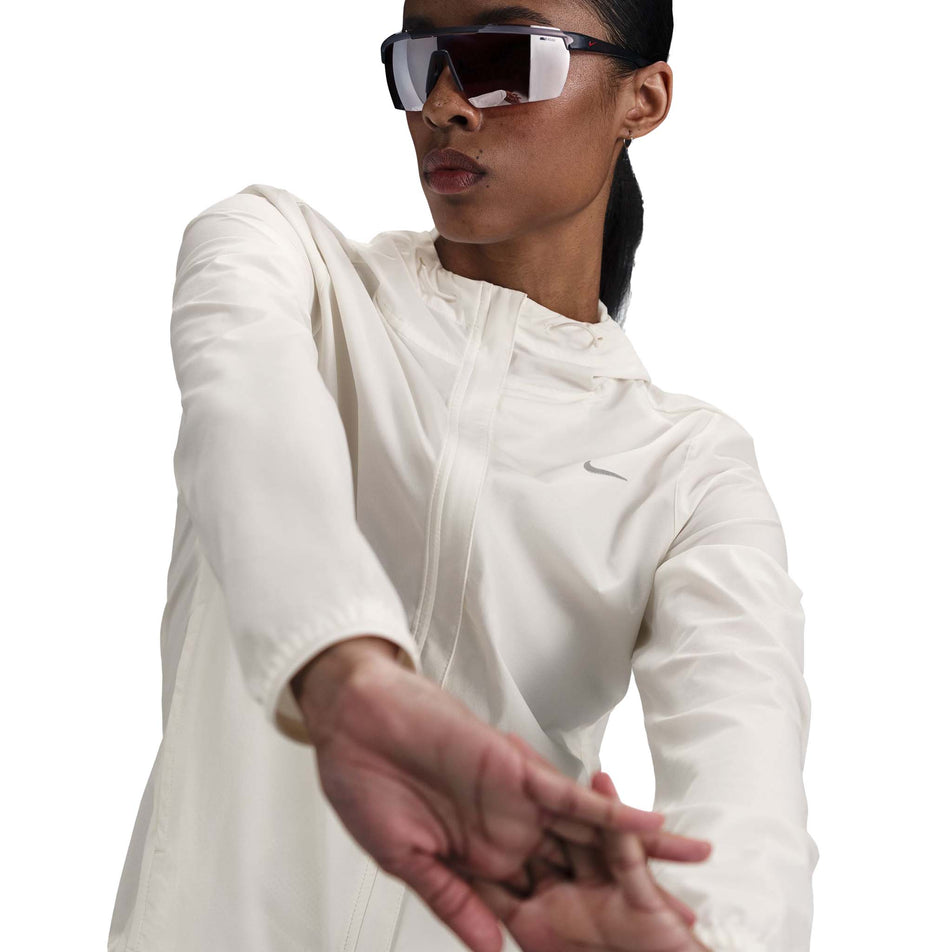 Front view of a model wearing the Nike Women's Swift Repel Packable Running Jacket in the Sail/Reflective Silver colourway. (8732499738786)