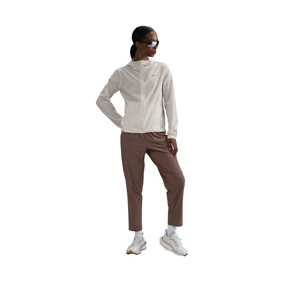 Front view of a model wearing the Nike Women's Swift Repel Packable Running Jacket in the Sail/Reflective Silver colourway. (8732499738786)