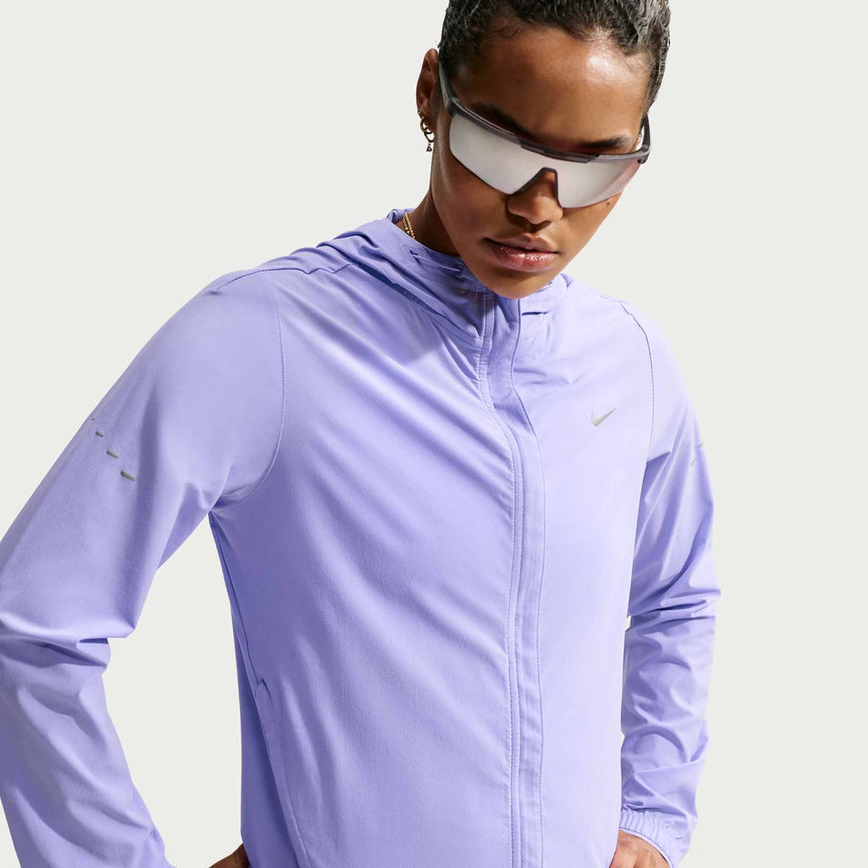 Front view of a model wearing the Nike Women's Swift Repel Packable Running Jacket in the Purple Pulse/Reflective Silver colourway.